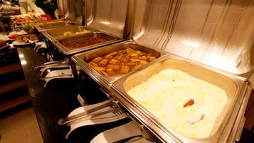 Un bufé con diversos alimentos y utensilios.