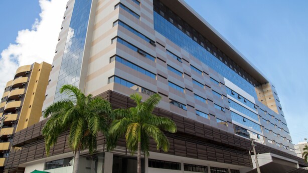 A modern high-rise building with a glass facade, multiple floors, and a flat roof. - Acqua Inn (Maceió)