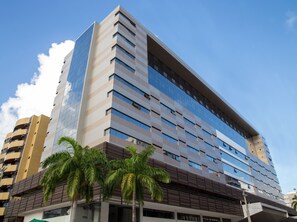 A modern high-rise building with a glass facade, multiple floors, and a flat roof. - Acqua Inn (Maceió)