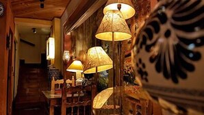 Interior acolhedor com luminárias tradicionais e uma peça decorativa em cerâmica.
