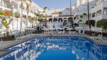Una piscina al aire libre, tumbonas