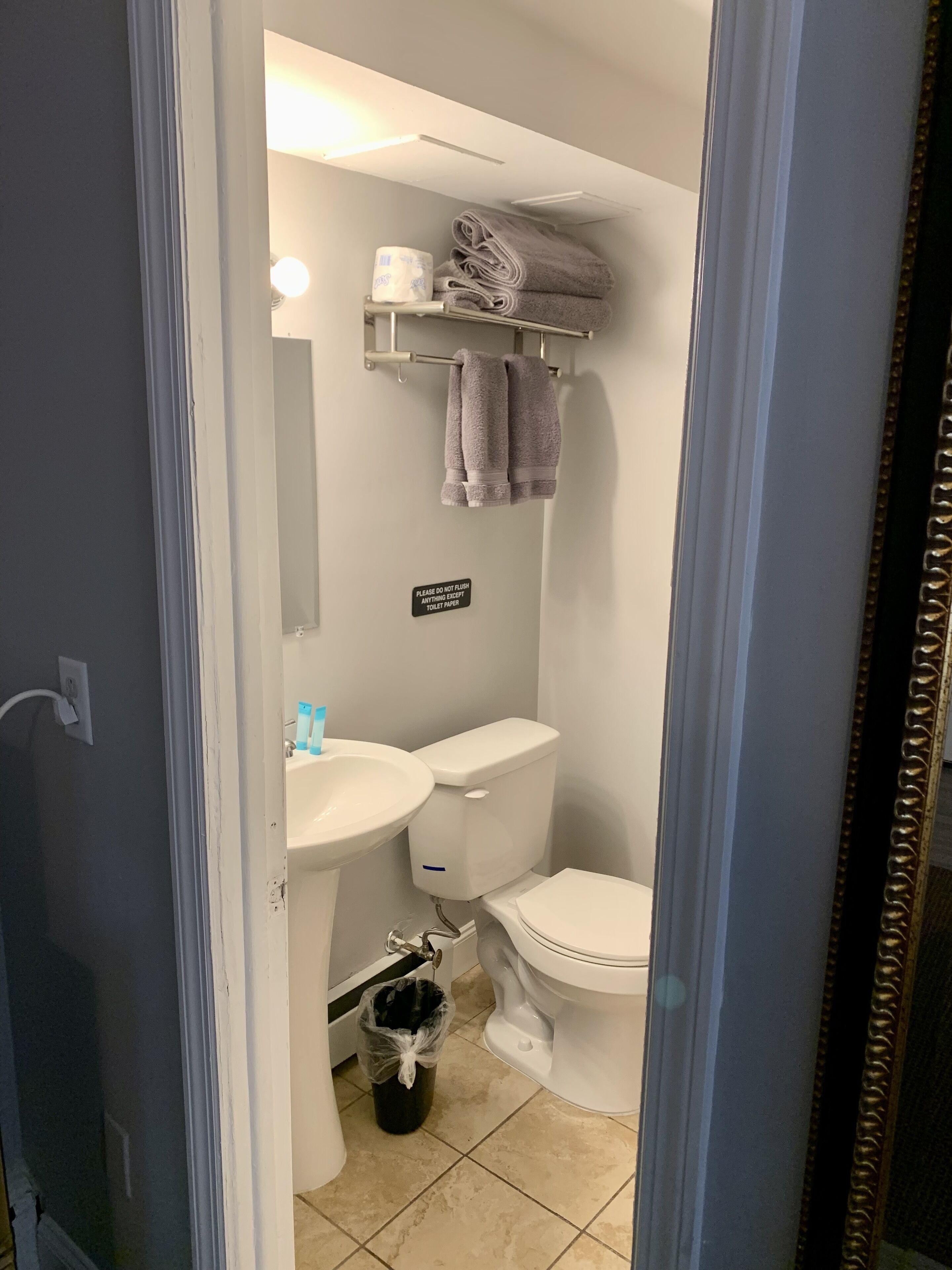 A bathroom with a toilet, sink, and towel rack.