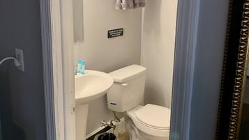 A bathroom with a toilet, sink, and towel rack.