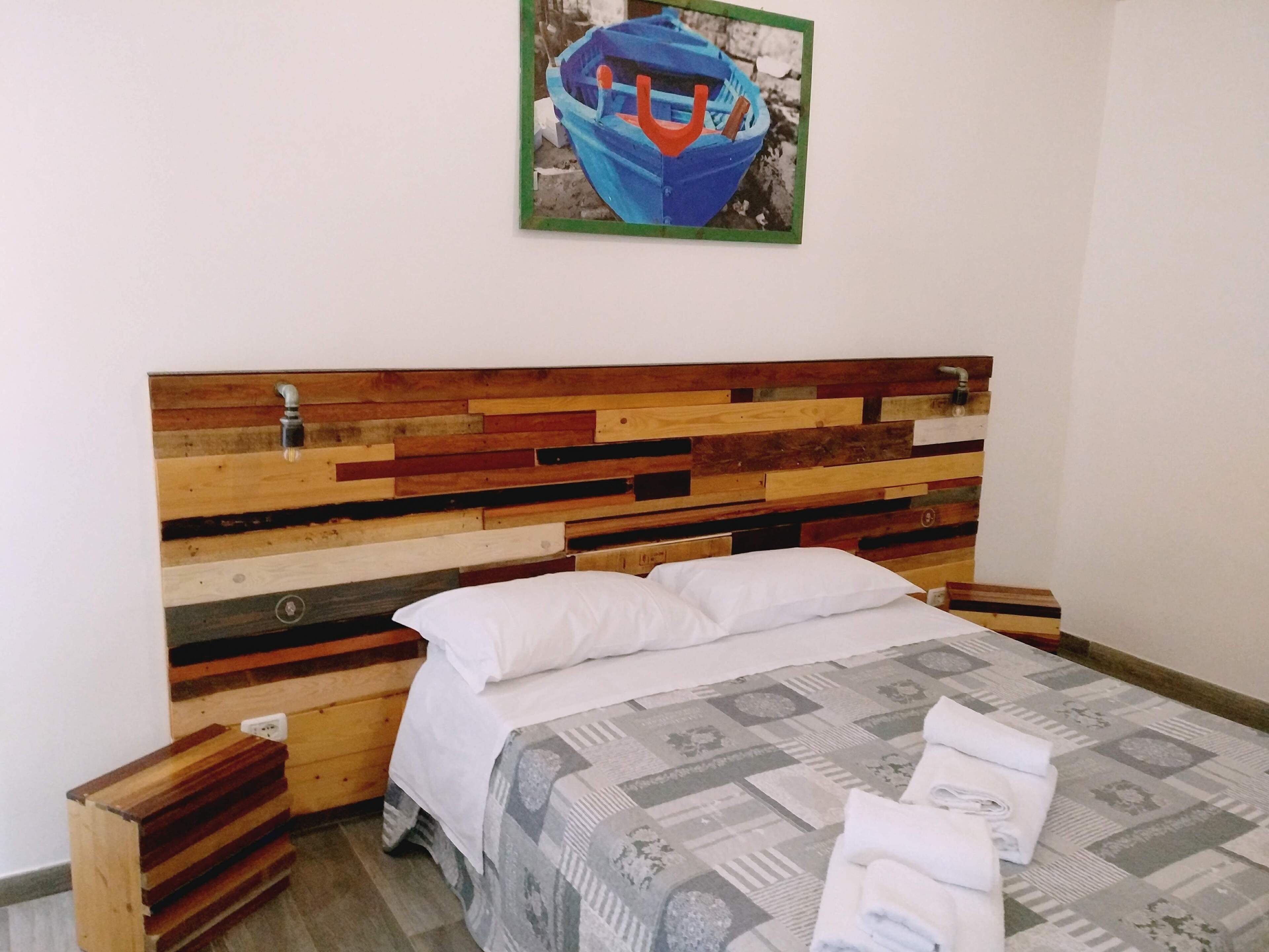 A bed with a wooden headboard, white pillows, and a patterned bedspread.