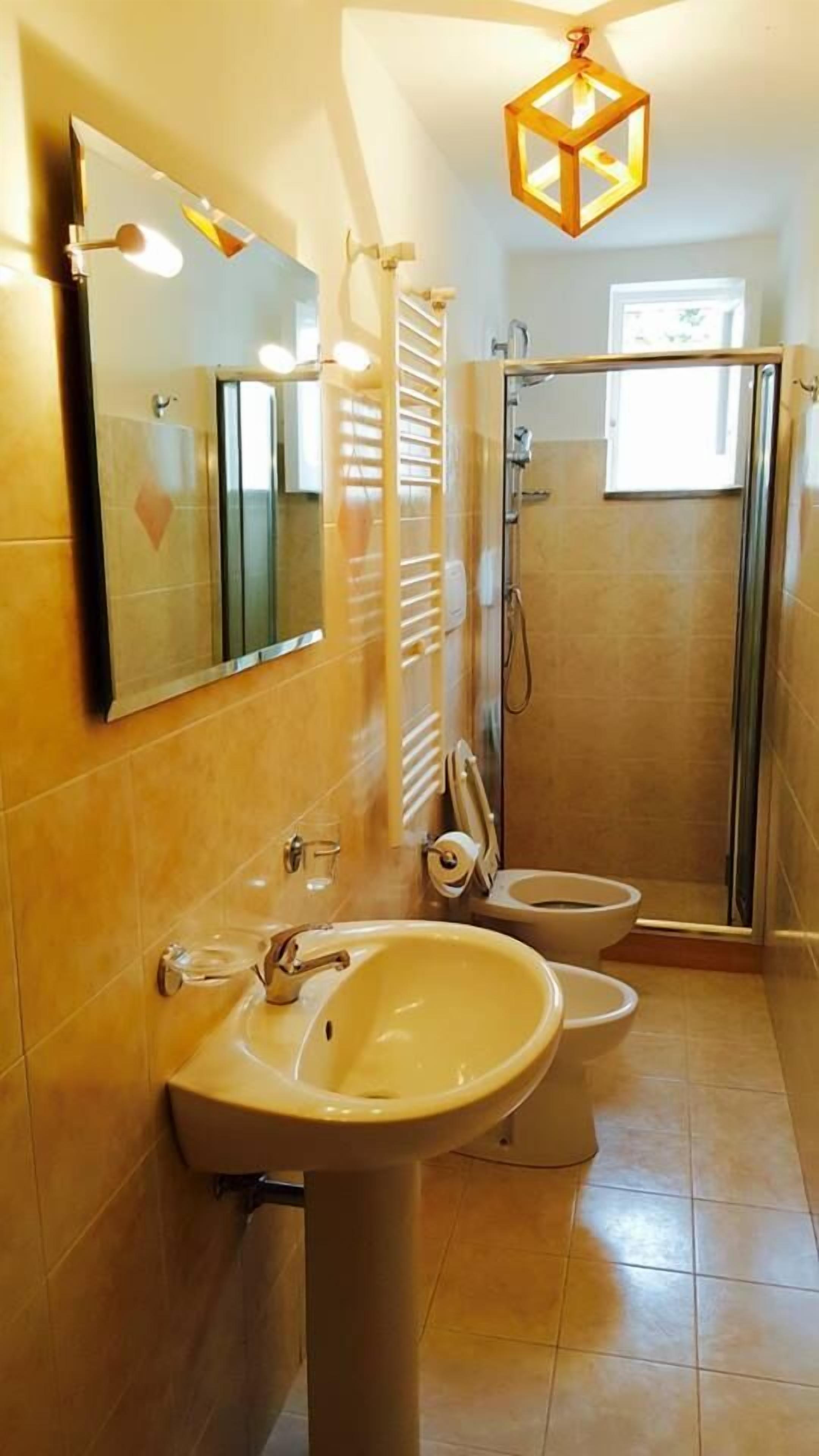 A bathroom with a sink, mirror, and a shower area.