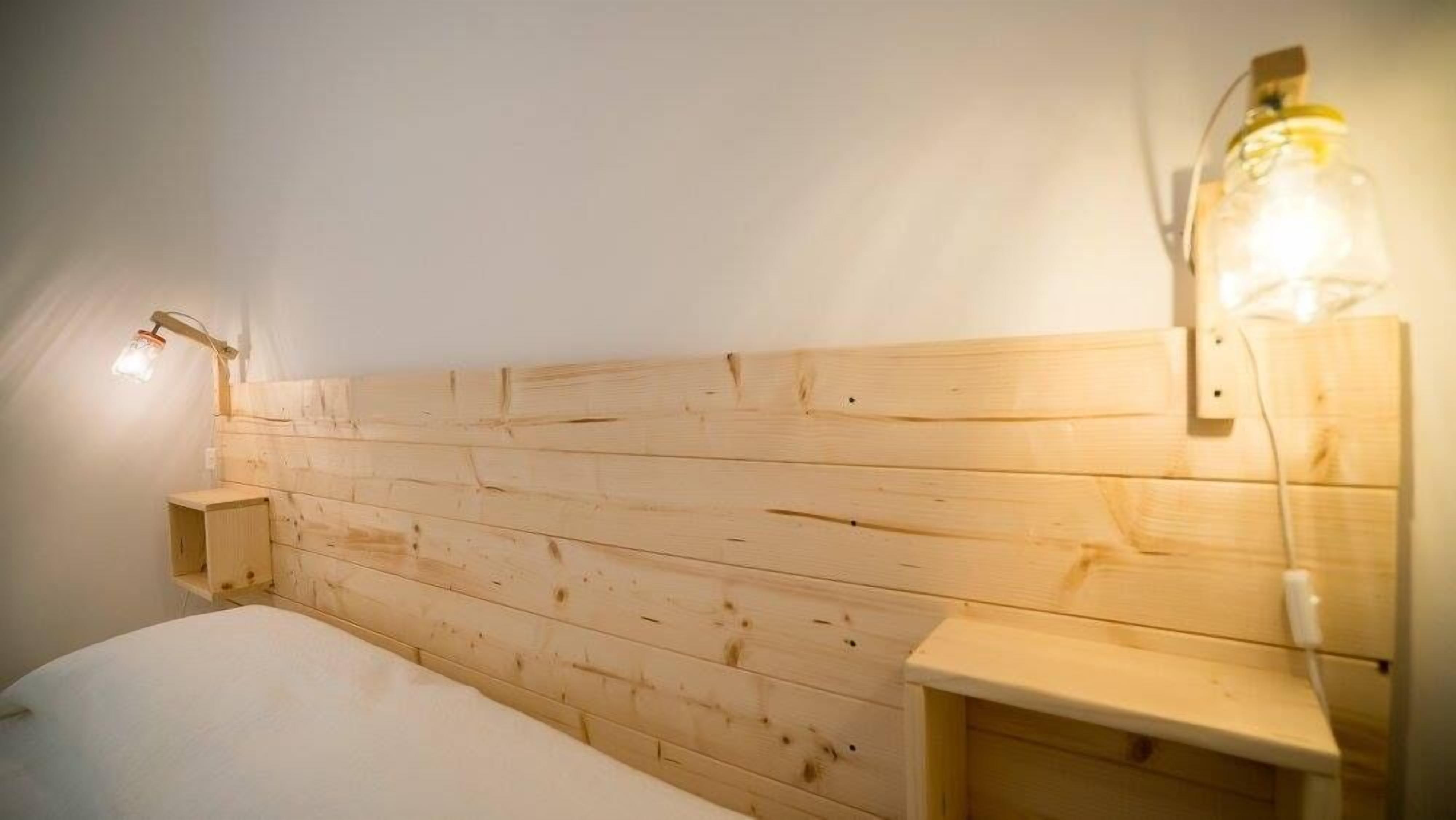 Een houten hoofdbord met ingebouwde verlichting.