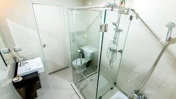 Un baño moderno con ducha envuelta en vidrio, un lavabo blanco y una bañera.