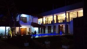 Vista frontal de la propiedad por la tarde o noche