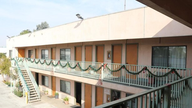 A building with a balcony decorated with festive garlands. - Four Corners motel (Montebello)