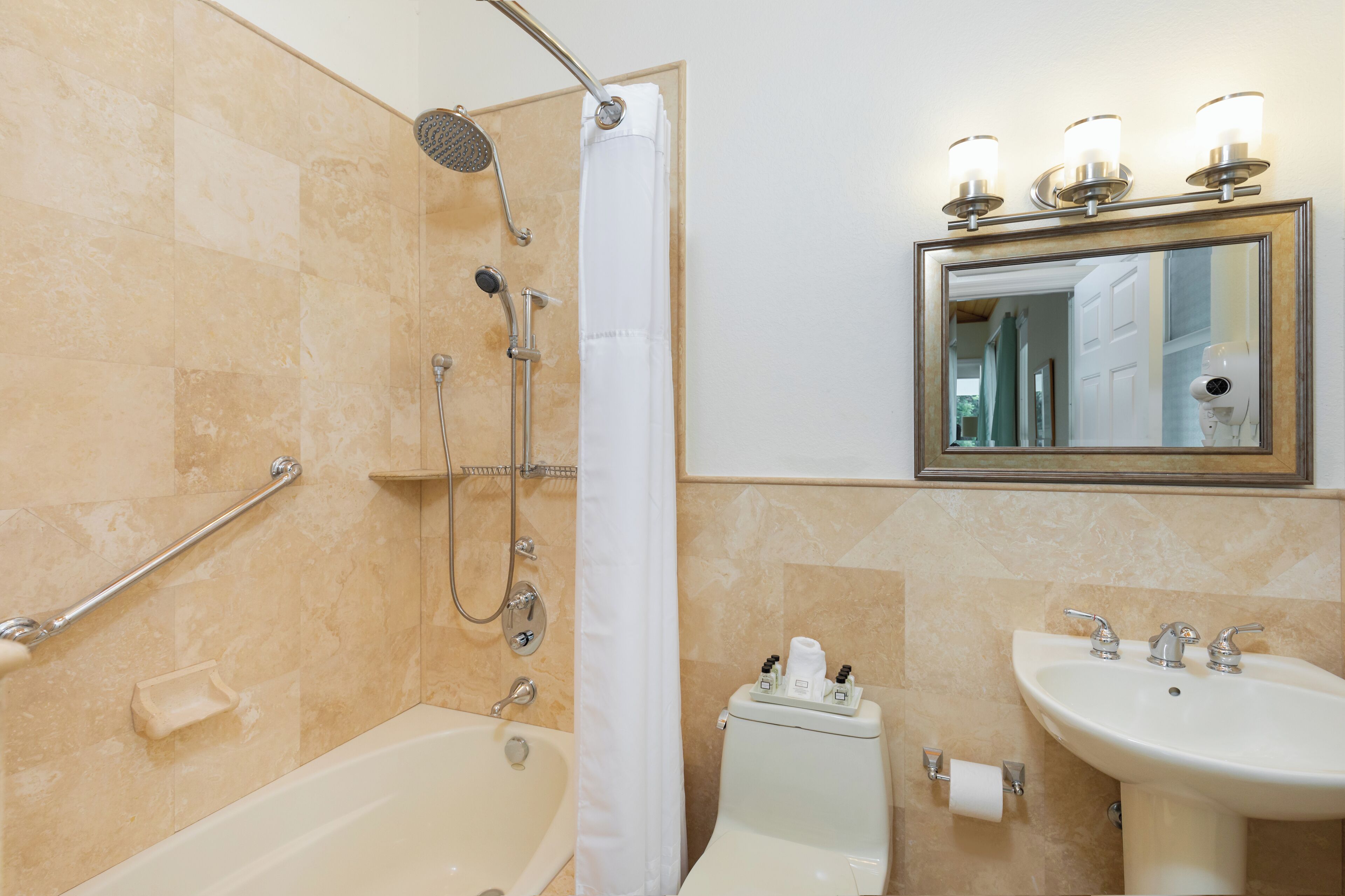A bathroom with a bathtub, shower, toilet, and sink.