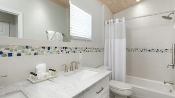 Une salle de bain moderne avec un lavabo en marbre, des toilettes et une baignoire.