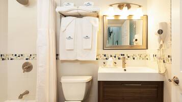 A bathroom with a shower, toilet, sink, and vanity.