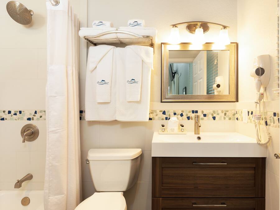 A bathroom with a shower, toilet, sink, and vanity.