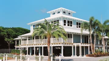 Un edificio grande de dos pisos con fachada blanca y varios balcones.