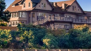 A large, multi-story house with a prominent balcony and a dock area with seals. - Noyo Harbor Inn Restaurant and Tavern (Fort Bragg)