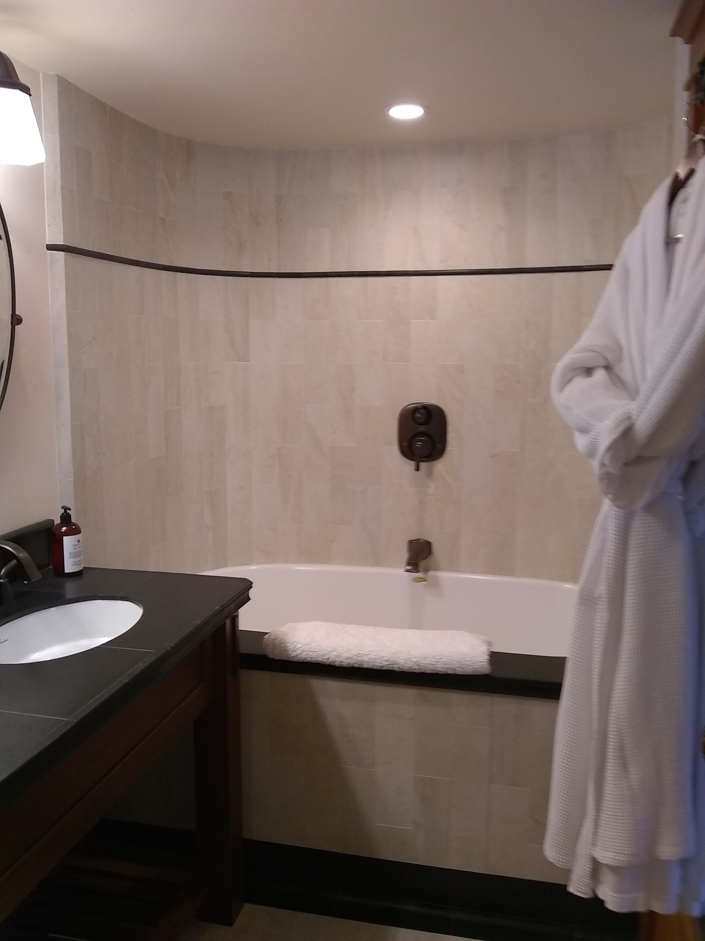 A bathroom with a bathtub, a sink, and a towel rack.