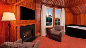 A cozy room with a fireplace, a television, a sofa, a small table, and a bathtub. - Noyo Harbor Inn Restaurant and Tavern (Fort Bragg)