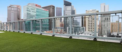 A modern building with a glass facade and a metal fence in the foreground.
