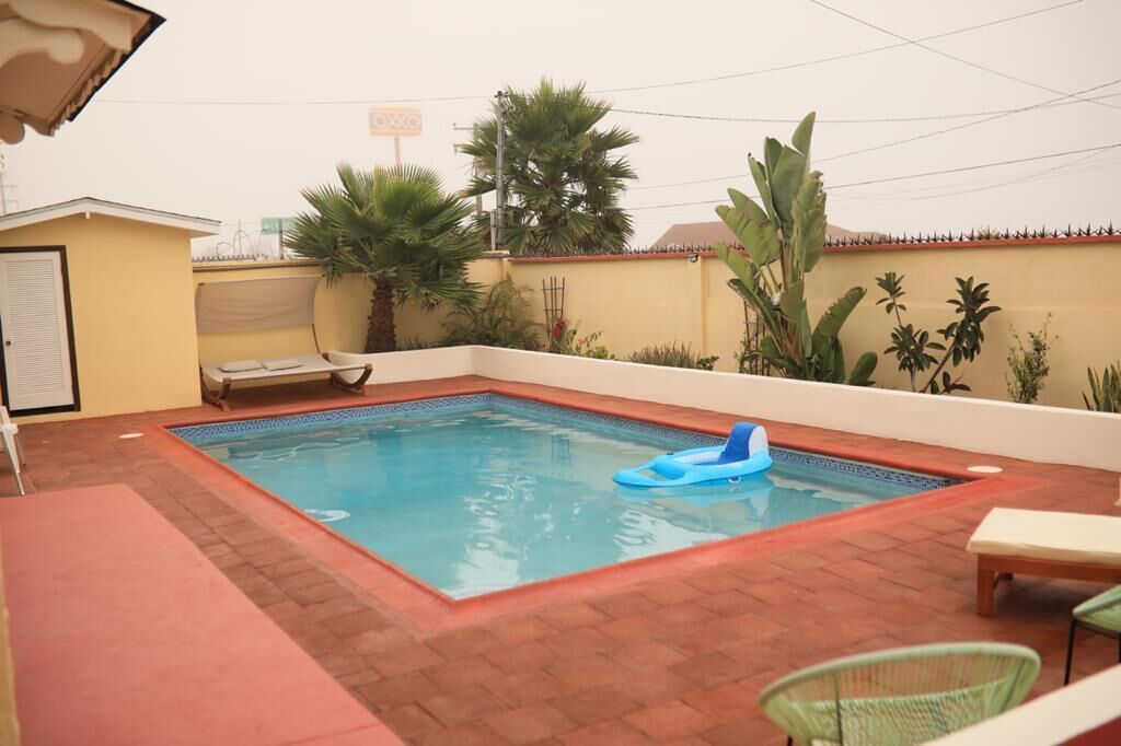 Una piscina al aire libre, sillones reclinables de piscina