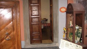 A room with a wooden door, a mirror, and a cabinet with a sign. - Bed & Breakfast del Teatro (Cagli)