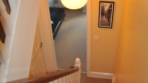 A staircase with white balusters and a carpeted landing.