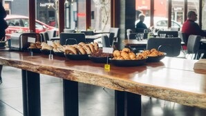 A breakfast buffet with various pastries and baked goods displayed on a wooden counter. - Harmon Guest House (Healdsburg)