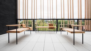 A modern outdoor seating area with three wooden benches and a central table, set against a backdrop of vertical wooden slats and a cityscape view. - Harmon Guest House (Healdsburg)