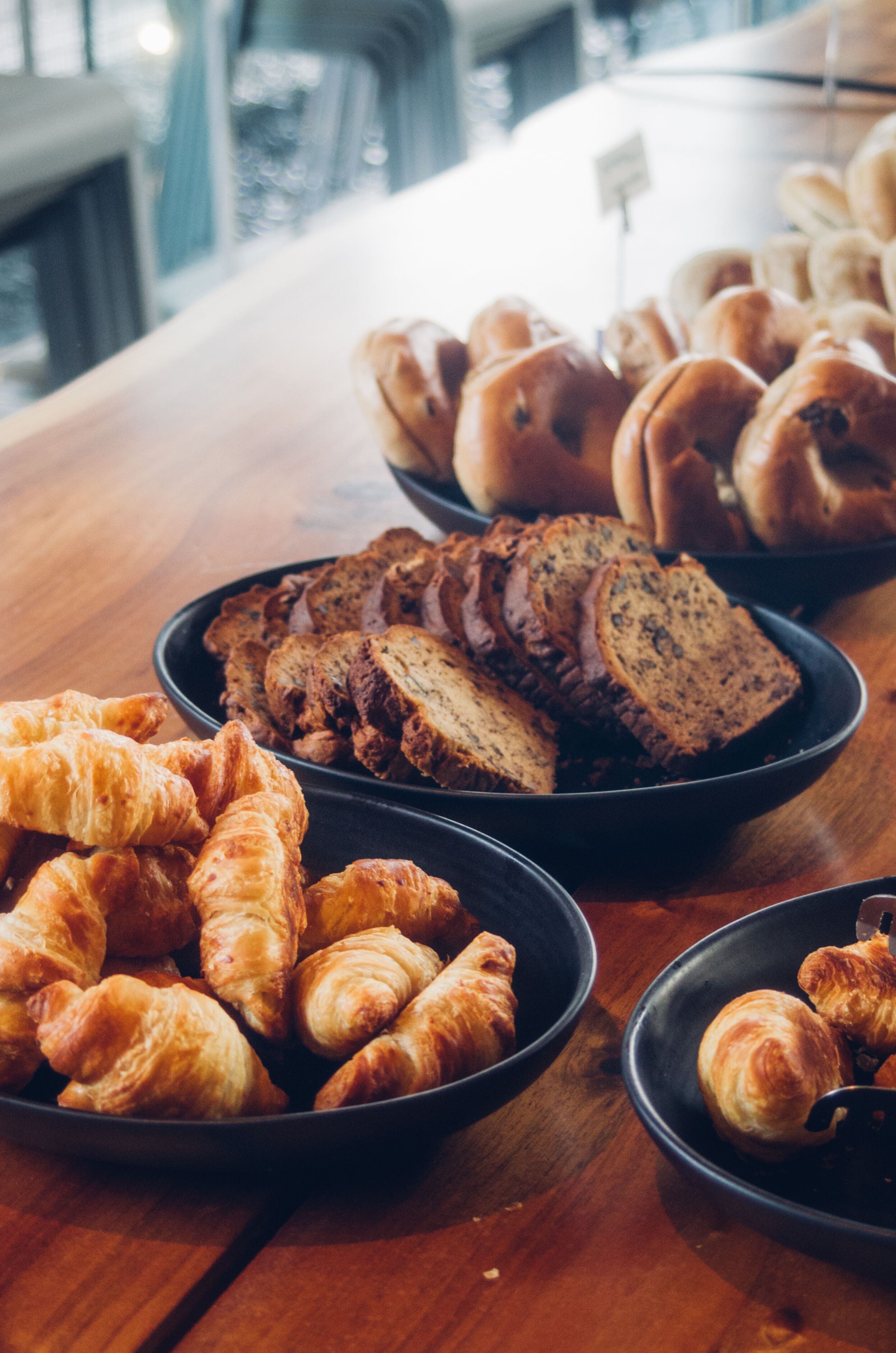 A variety of baked goods including croissants and bread on a wooden table.