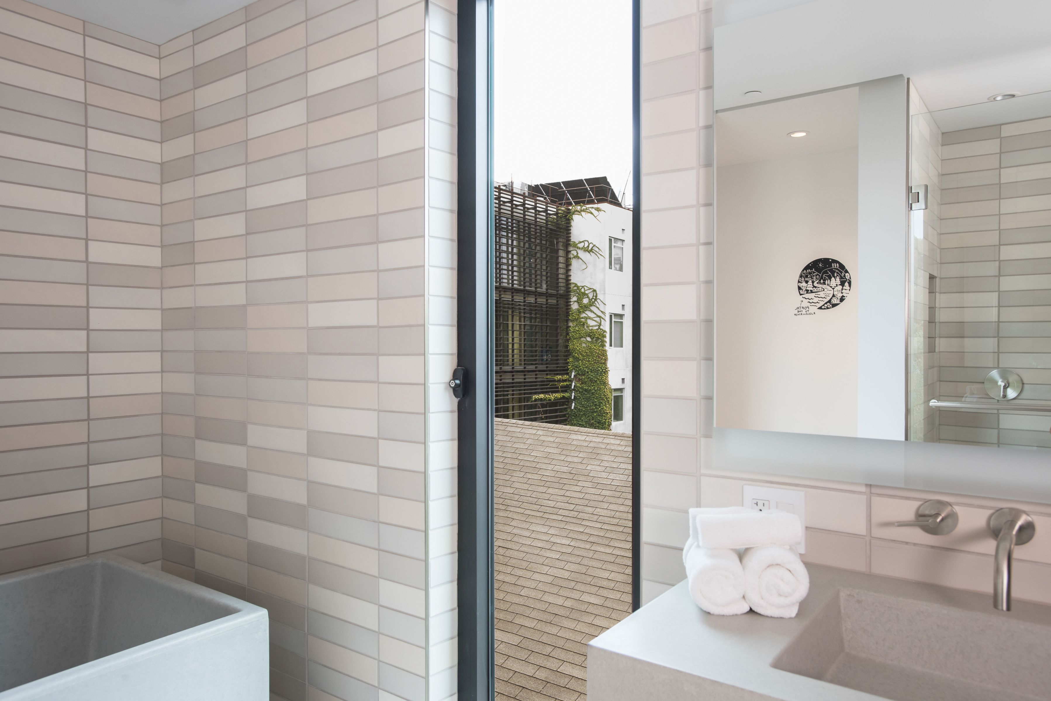 A modern bathroom with a large bathtub, a sink, and a mirror.