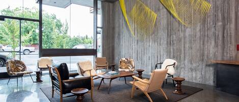 A modern lobby with large windows, a variety of seating options, and a unique yellow wall art installation.
