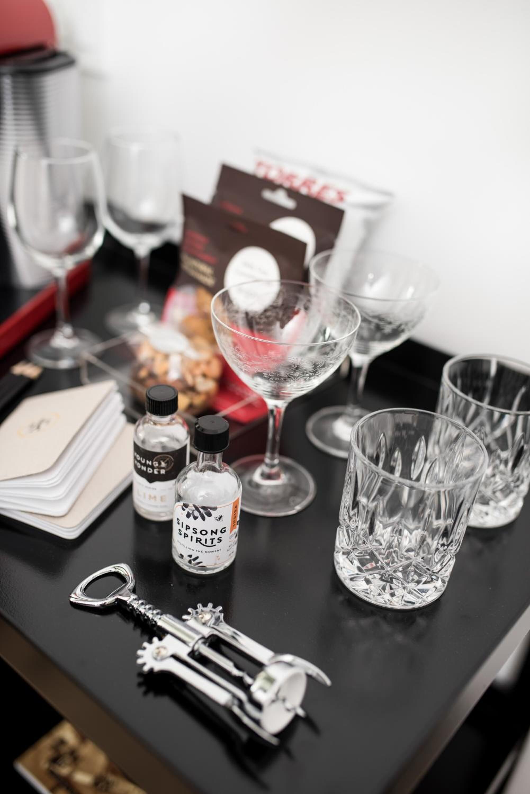 Een tafel met verschillende voorwerpen, waaronder glazen, flessen en een sleutel.