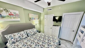 A bedroom with a bed, a TV, a wardrobe, and a painting on the wall. - Highly Rated, 2 Bed/2 Bath Ocean Reef Condo, Fabulous Reviews, Beach Service (Panama City Beach)