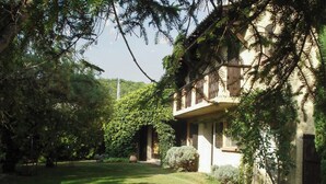 A building with a balcony, surrounded by lush greenery and a well-maintained lawn. - Homerez - Provencal Villa with Pool in Barbentane (Barbentane)