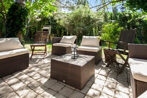 An outdoor patio area with wicker furniture, including sofas and a coffee table, set on a paved surface. - Homerez - Provencal Villa with Pool in Barbentane (Barbentane)