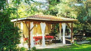 A gazebo with a tiled roof and white columns, surrounded by greenery. - Homerez - Provencal Villa with Pool in Barbentane (Barbentane)