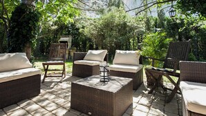 An outdoor patio with wicker furniture, including sofas and chairs, arranged on a paved surface. - Homerez - Provencal Villa with Pool in Barbentane (Barbentane)