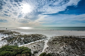 Une plage avec des dunes de sable et un ciel dégagé.