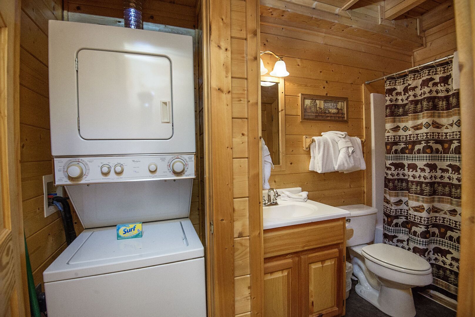 Une petite salle de bain équipée d’un lave-linge, d’un évier et de toilettes.