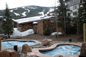 A spa area with two hot tubs surrounded by rocks and snow. - Ski mountain views, hot tubs and small heated pool! Free Parking and Wifi (Copper Mountain)