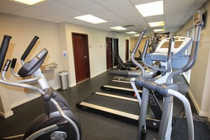 Un centre de remise en forme équipé de tapis de course, de vélos d’appartement et d’appareils elliptiques.