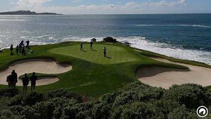 Campo de golf con búnkeres y vista al océano.
