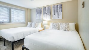 A hotel room with two beds, a window with blinds, a wall-mounted lamp, and three wall art pieces. - Outpost: Tensleep B1 - Hot Tub Access (Teton Village)