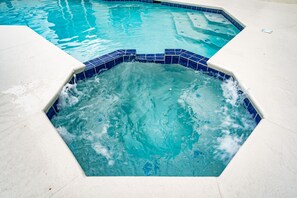 A swimming pool with a hexagonal hot tub area.