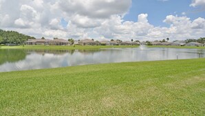 A residential area with houses, a pond, and a clear sky. - Budget Friendly! Lake View Home with a Private pool nearby to Disney (Davenport)