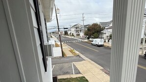 Vista de una calle residencial con casas, aceras y un espacio verde.