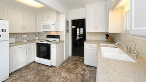 A modern kitchen with white cabinets, a stove, microwave, and a sink. - 359CA: Charming Family Home, 3 Blocks to Beach, Restaurants and Shops (Avalon)