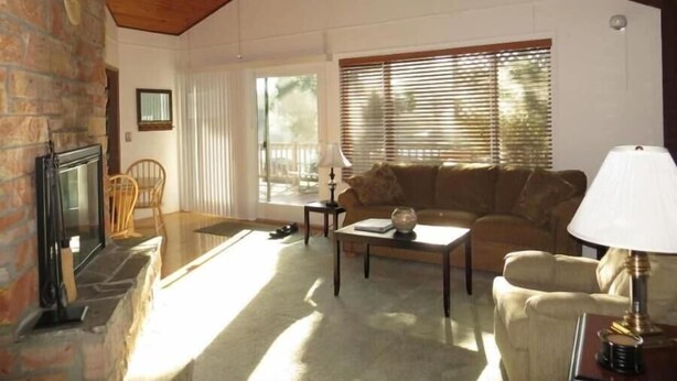 A cozy living room with a fireplace, a sofa, a coffee table, and a lamp.