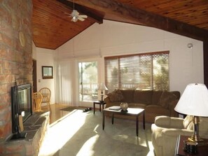 A cozy living room with a fireplace, a sofa, a coffee table, and a lamp. - Sea Star Spa – Hot Tub, Walk to Beach (Florence)