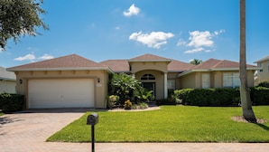 A residential house with a garage, a well-maintained lawn, and a mailbox.
