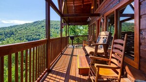 Un pontile di legno con vista su una catena montuosa boscosa.
